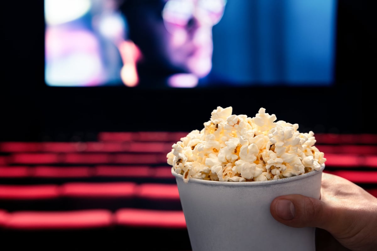 Sala de cine en penumbra con butacas rojas